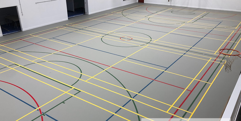 Grey synthetic Herculan MF Blue 28 sports floor at Golden Bay High School with dense yellow, blue, red and green court line marking